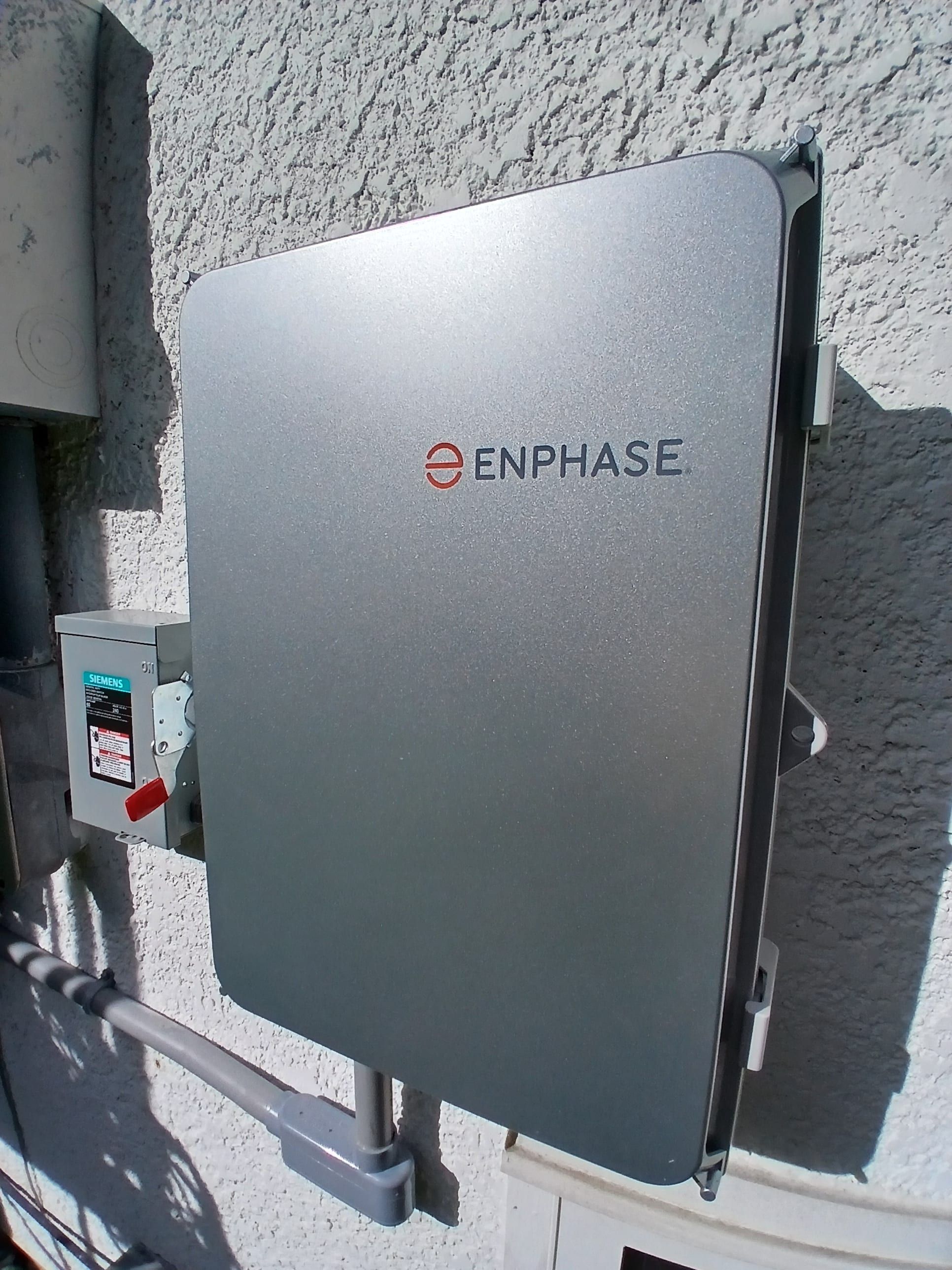 Wall-mounted Enphase equipment beside a Siemens fused disconnect.